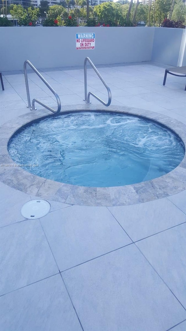 view of pool featuring a hot tub and a patio