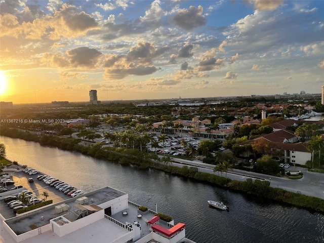 aerial view at dusk featuring a water view