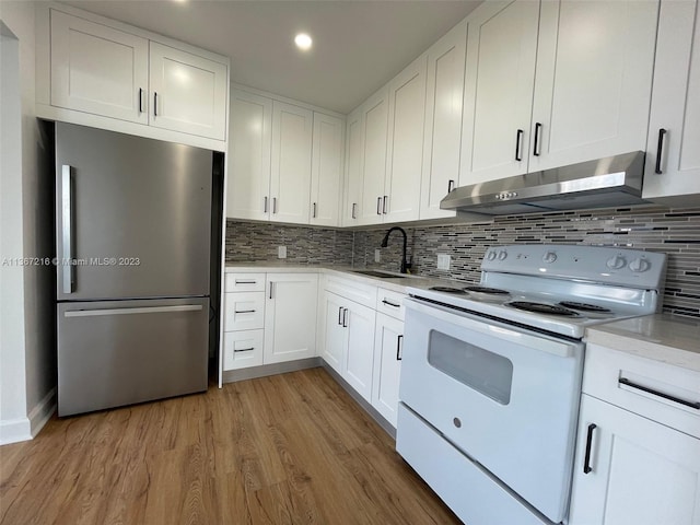 kitchen with white cabinetry, sink, white electric range, and stainless steel fridge