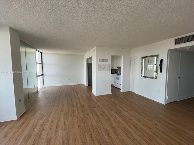 unfurnished living room with hardwood / wood-style floors and a textured ceiling