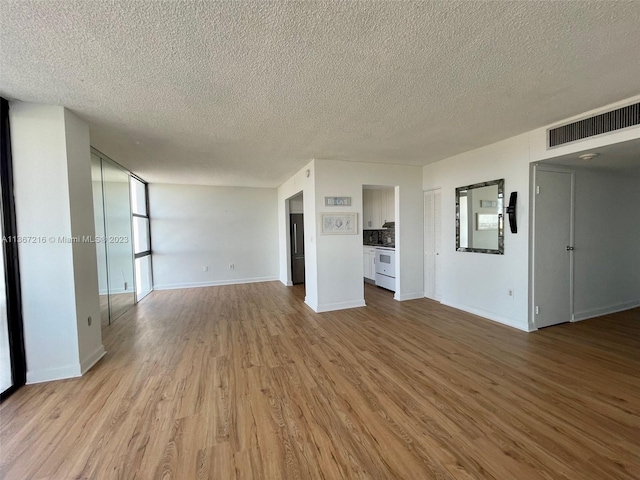 unfurnished living room featuring a textured ceiling and light hardwood / wood-style flooring