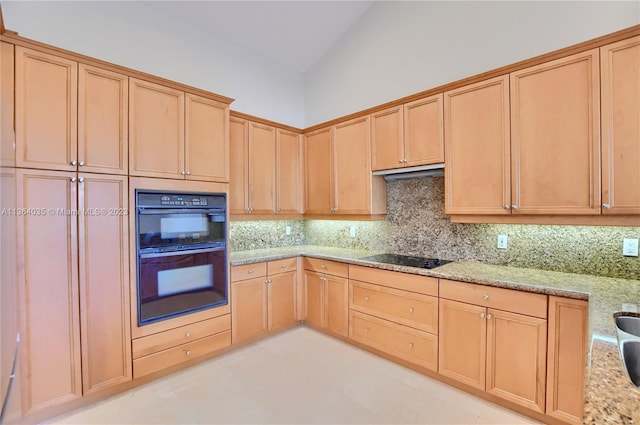 kitchen with backsplash, light tile flooring, vaulted ceiling, light stone countertops, and black appliances