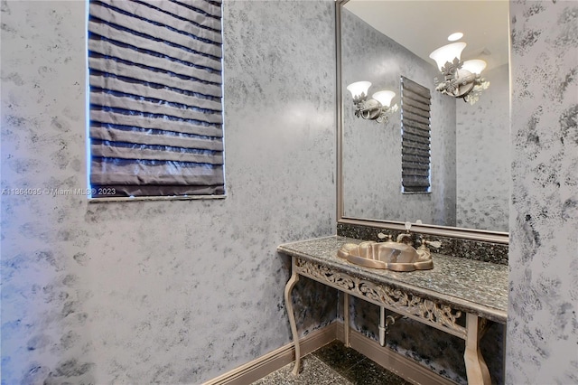 bathroom with tile floors, a chandelier, and vanity with extensive cabinet space