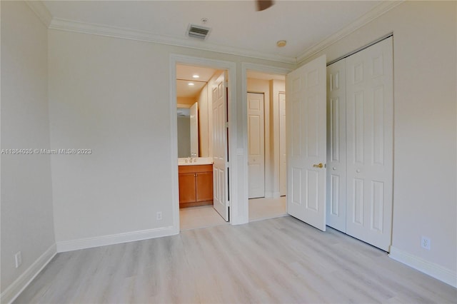 unfurnished bedroom with connected bathroom, a closet, and light wood-type flooring