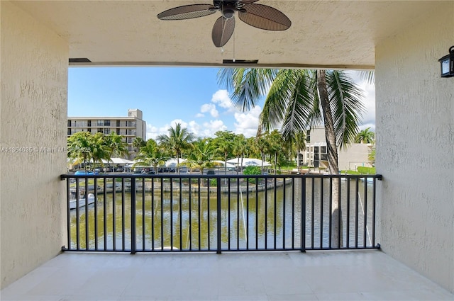 balcony with a water view and ceiling fan