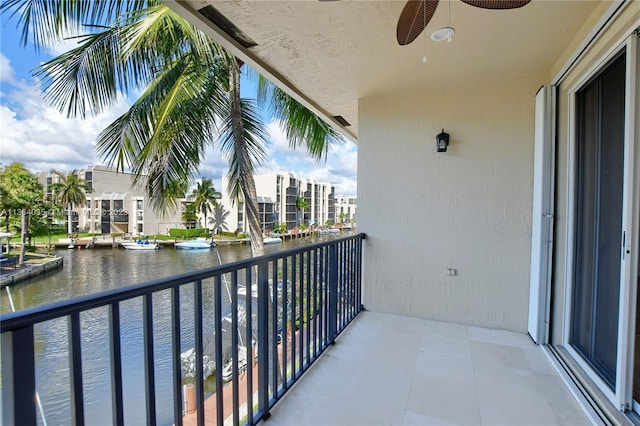 balcony featuring a water view and ceiling fan