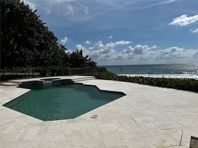 view of swimming pool featuring a patio and a water view