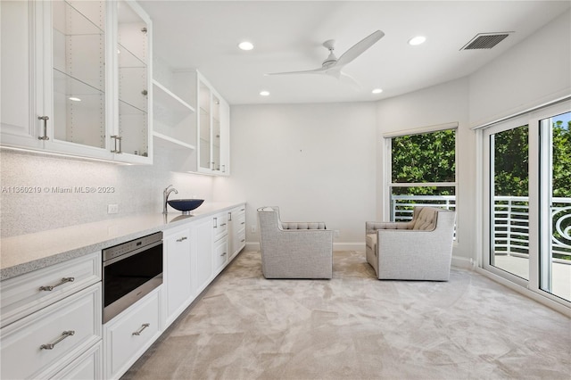 kitchen with white cabinets, ceiling fan, and a wealth of natural light