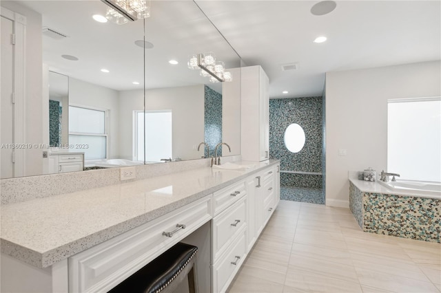 bathroom featuring tile floors, a notable chandelier, vanity, and a bath to relax in