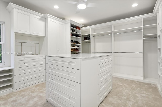 spacious closet with light carpet and ceiling fan