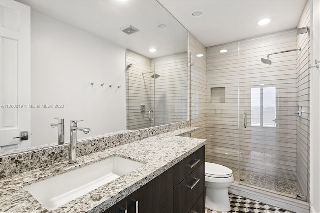 bathroom with a shower with door, tile flooring, oversized vanity, and toilet