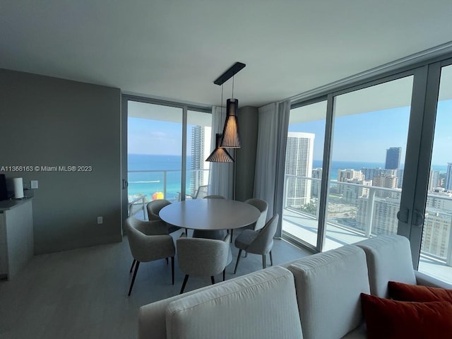 dining room with a water view, french doors, and a wall of windows