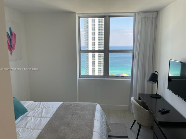 bedroom with a water view and light wood-type flooring