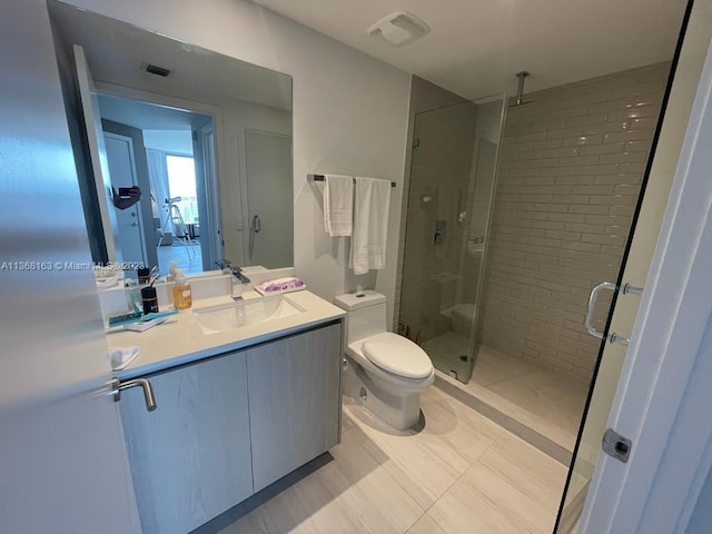 bathroom featuring a shower with door, tile floors, toilet, and vanity