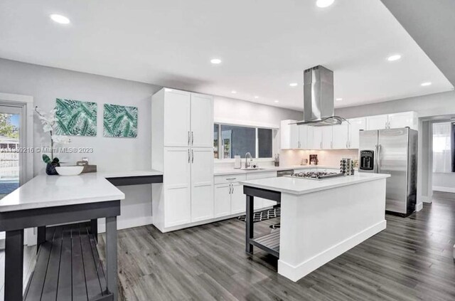 kitchen featuring sink, stainless steel appliances, dark wood-type flooring, island range hood, and white cabinetry