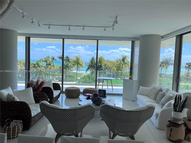 living room with plenty of natural light, floor to ceiling windows, and rail lighting