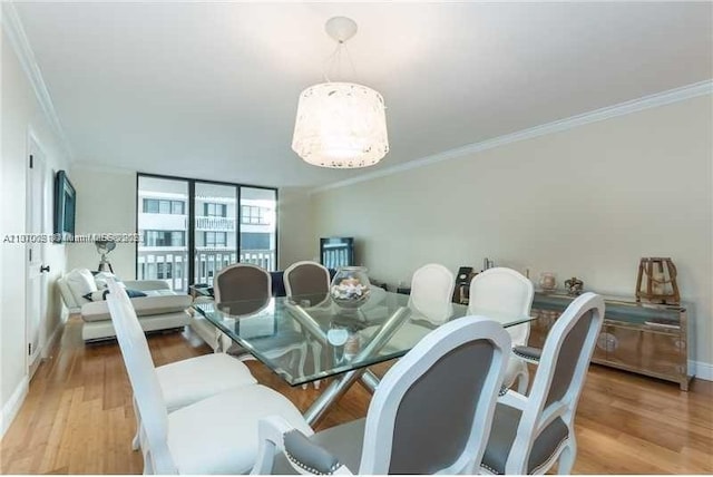 dining room with a wall of windows, crown molding, and light hardwood / wood-style flooring