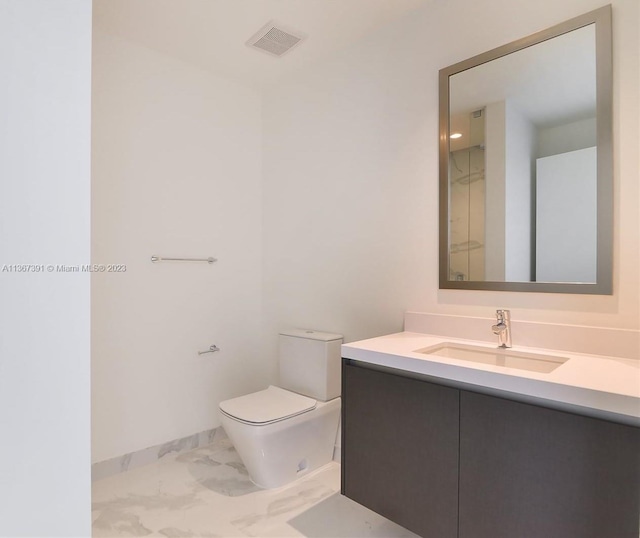 bathroom with toilet, vanity, and tile flooring