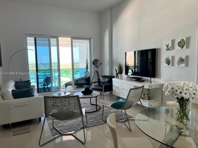 living room featuring a high ceiling and light tile flooring