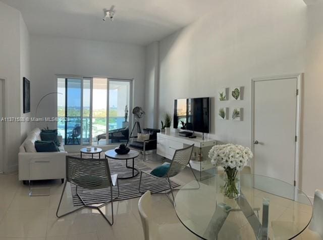 tiled living room featuring a towering ceiling