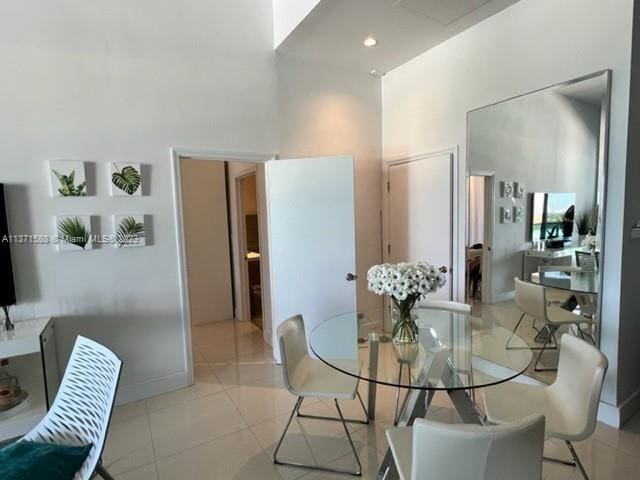 dining area with light tile flooring and a high ceiling