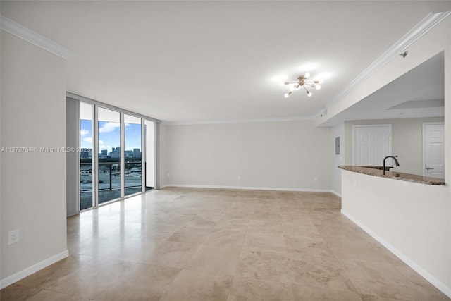 unfurnished living room featuring expansive windows, an inviting chandelier, sink, light tile floors, and crown molding