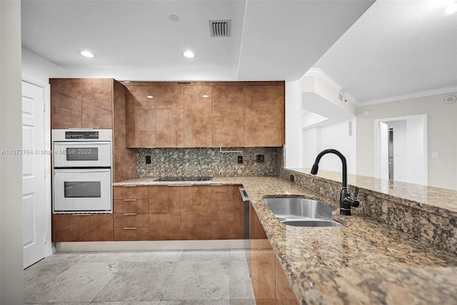 kitchen with crown molding, light stone countertops, sink, light tile flooring, and multiple ovens