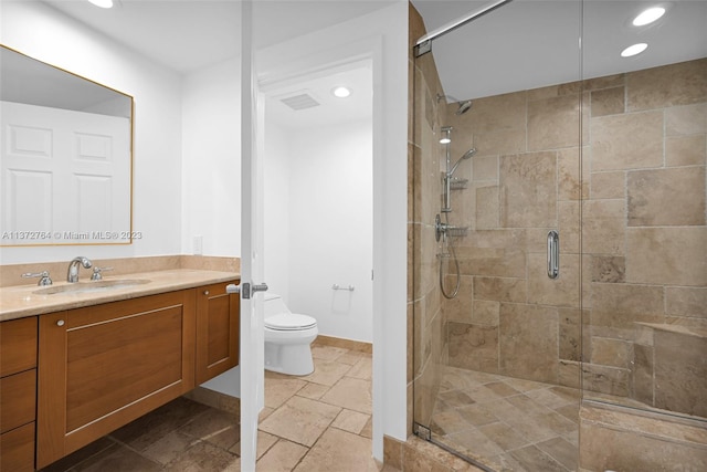 bathroom featuring tile flooring, vanity, toilet, and a shower with shower door