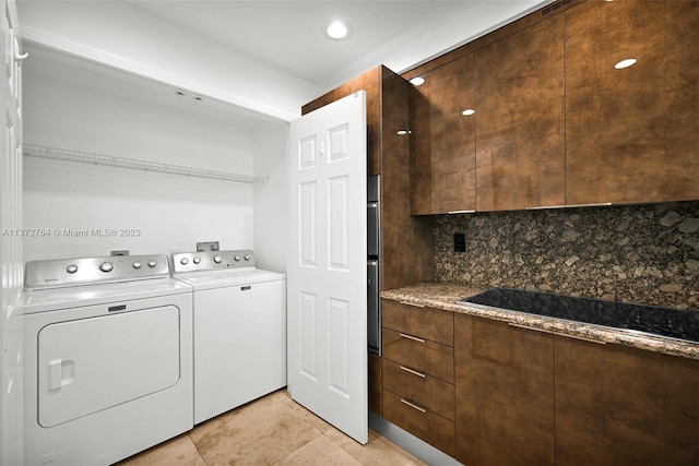 laundry area with washer hookup, light tile floors, and washing machine and dryer