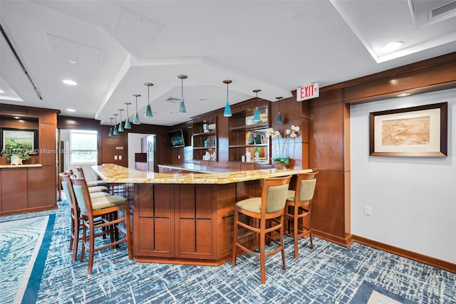 bar featuring light stone countertops, hanging light fixtures, carpet floors, and vaulted ceiling