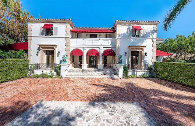 view of front of house featuring a balcony and french doors