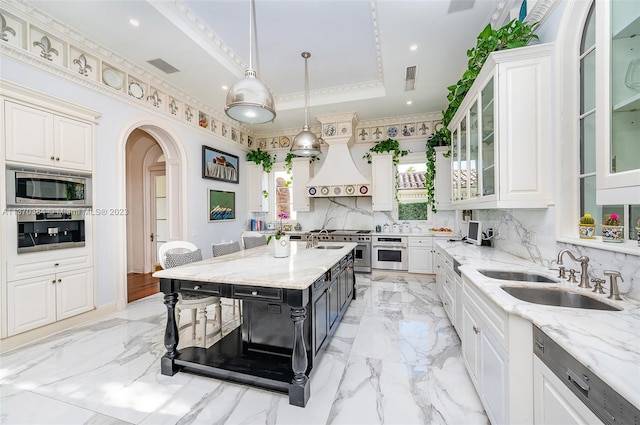 kitchen featuring white cabinetry, sink, stainless steel appliances, a raised ceiling, and tasteful backsplash