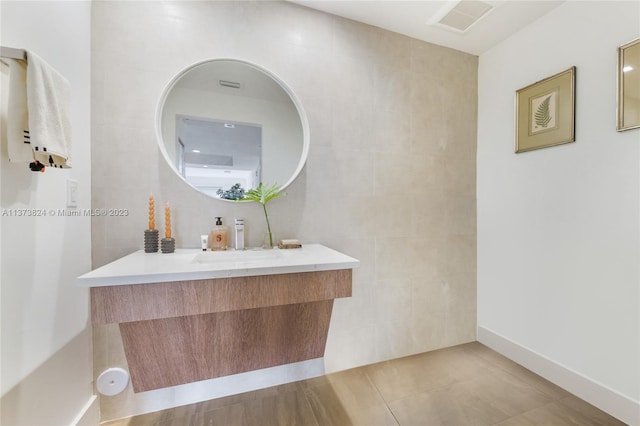 bathroom with tile floors, oversized vanity, and tile walls