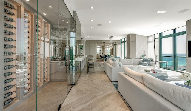 living room with plenty of natural light, light parquet flooring, a water view, and expansive windows