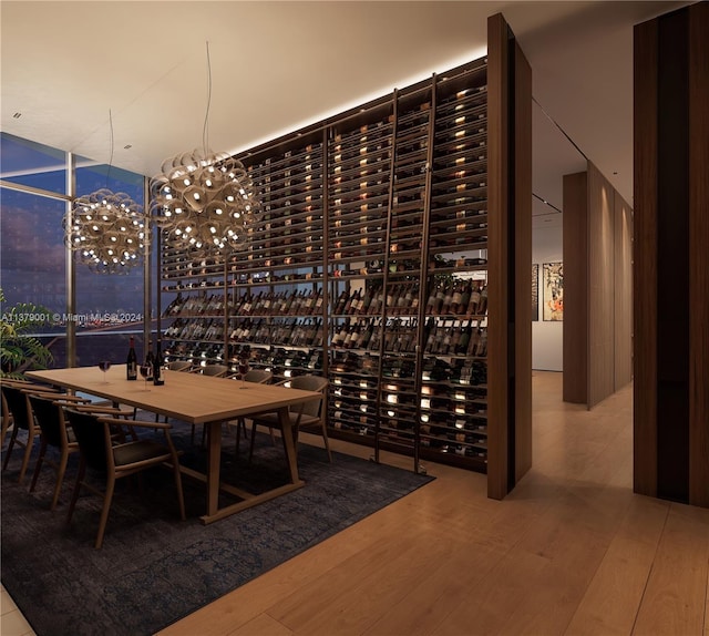 wine area with wood-type flooring and a notable chandelier