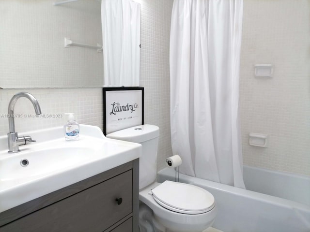 full bathroom featuring vanity, shower / bath combo with shower curtain, and toilet