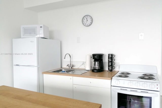 kitchen with white cabinets, white appliances, and sink