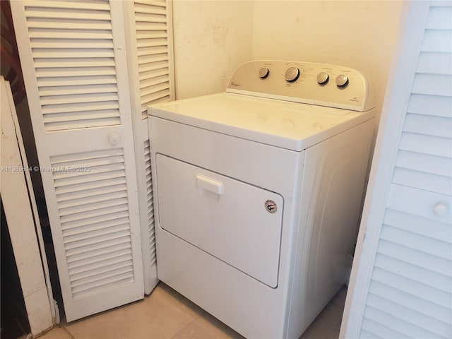 clothes washing area with light tile floors and washer / clothes dryer