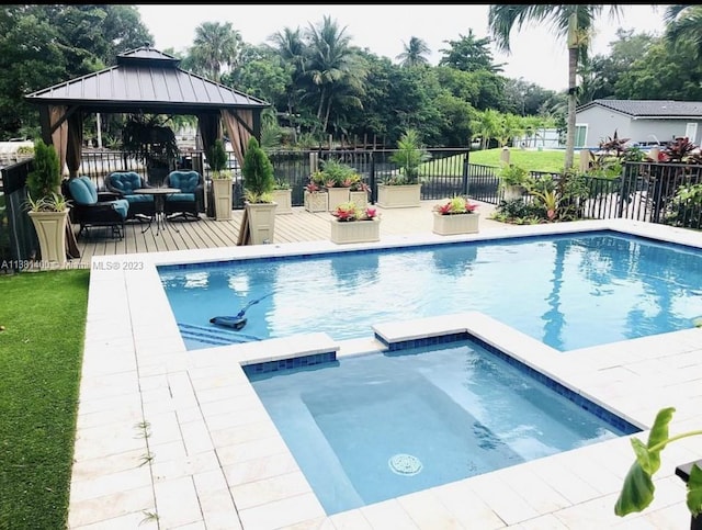 view of swimming pool featuring a gazebo, an in ground hot tub, and a lawn