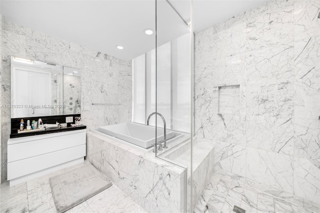 bathroom featuring tiled bath, tile walls, tile floors, and vanity