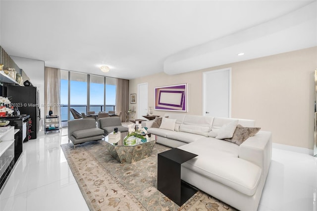 living room with floor to ceiling windows, a water view, and light tile flooring