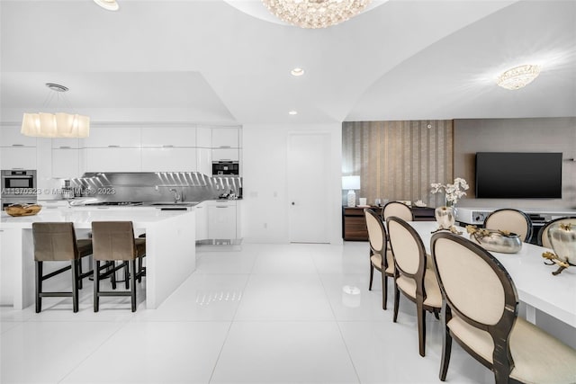 tiled dining area featuring an inviting chandelier and sink