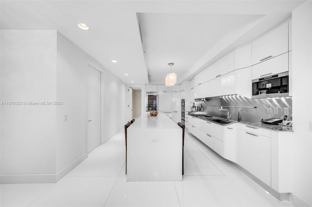 kitchen with pendant lighting, tasteful backsplash, white cabinets, and light tile floors