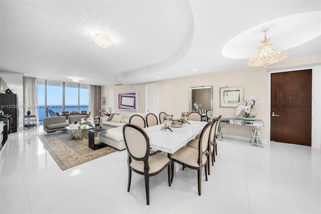 dining area with a chandelier, a water view, floor to ceiling windows, and light tile floors