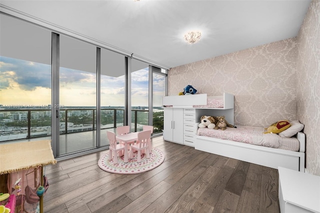 interior space featuring floor to ceiling windows, dark hardwood / wood-style flooring, and a water view