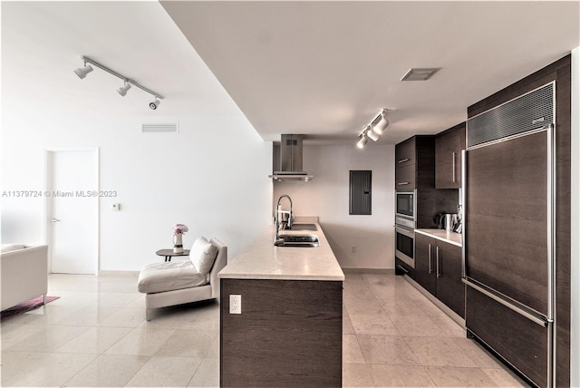 kitchen with extractor fan, paneled built in fridge, track lighting, and sink