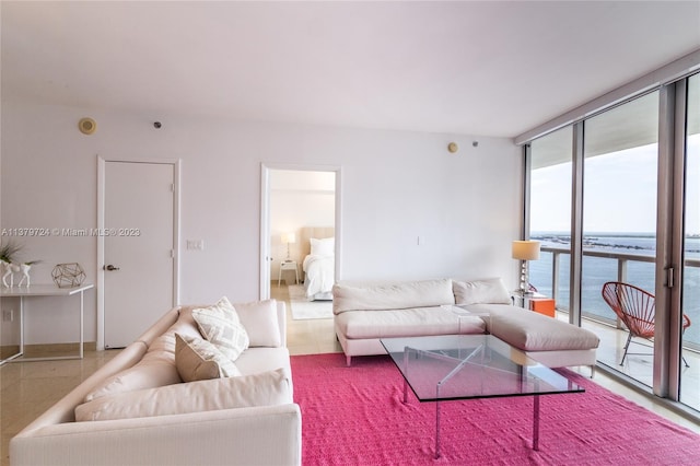 living room with light tile floors, floor to ceiling windows, and a water view