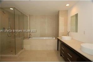 bathroom with dual vanity, tile floors, and separate shower and tub