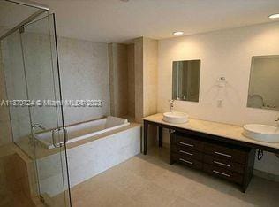 bathroom featuring independent shower and bath and double sink vanity