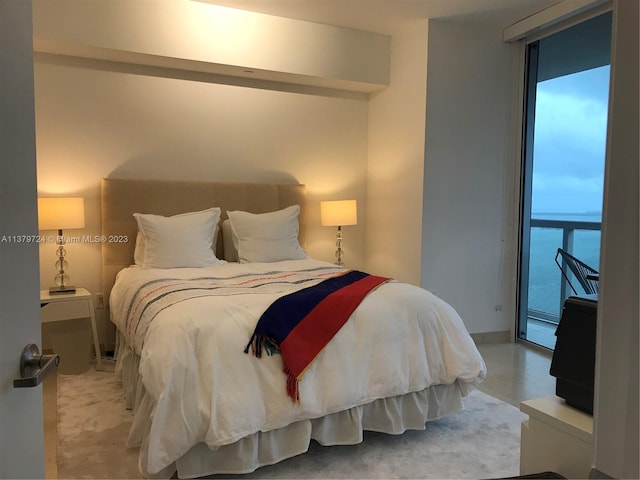 bedroom featuring a water view, access to exterior, and a wall of windows